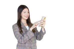 Fachmann jung asiatisch Geschäft Frau Büro Arbeiter mit schwarz lange Haar tragen ein Plaid passen und ziemlich glücklich mit ein Smartphone während isoliert auf Weiß Hintergrund. foto