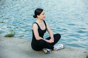 jung Frau im schwarz Sportbekleidung ausüben draußen. Fitness und gesund Lebensstil Konzept. das Weiß Mädchen tut Sport im das Park. foto