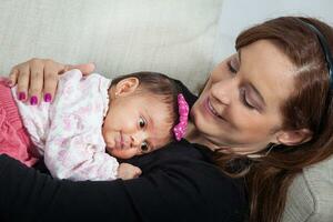 Porträt von schön jung Mutter beim Zuhause mit ihr einer Monat Baby Mädchen. Mutterschaft Konzept. Familie Liebe Konzept. foto