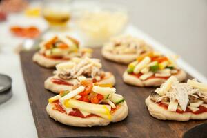 bereit zu Sein gebacken Mini Pizzen. köstlich Zuhause gemacht Mini Pizza Vorbereitung. foto