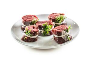 Rindfleisch Steak Wraps mit frisch Kräuter und Speck auf ein Teller auf ein isoliert Weiß Hintergrund foto