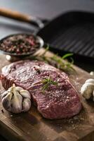 Rippe Auge Steak Salz- Pfeffer Gewürze Knoblauch und Pilz. roh Rindfleisch Fleisch auf Metzger Tafel foto