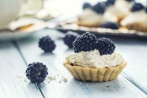 Mini Törtchen mit Brombeeren ausgepeitscht Sahne und Kaffee. foto