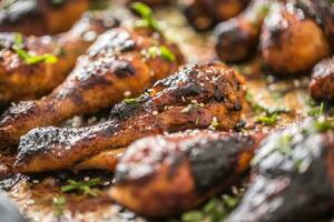 gegrillt hucken Beine Grill mit Gewürze Kräuter und Sesam auf gebacken Papier. geröstet Geflügel Mahlzeit im Bräter Gericht foto