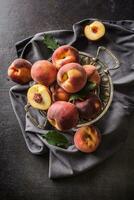 ein Gruppe ein reif Pfirsiche im rustikal Schüssel foto