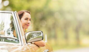 Frau Sitzung im ein Cabriolet Auto lächelnd während Fahren auf ein heiß Sommer- Tag foto