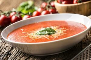 heiß Tomate Suppe Parmesan Käse und Basilikum verlassen auf alt öl Tabelle foto