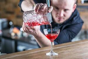 Barmann im Kneipe oder Restaurant vorbereiten ein Cocktail trinken foto