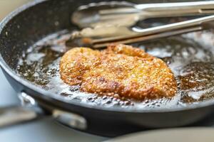 Schnitzel braten im ein heiß schwenken fertig zu golden knusprig Haut foto