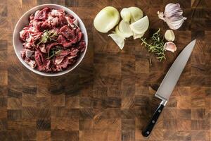 geschnitten Stücke von Rindfleisch im Teller mit Rosmarin Zwiebel und Knoblauch foto