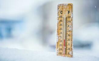 Thermometer auf Schnee zeigt an niedrig Temperaturen im Celsius oder Fahrenheit foto