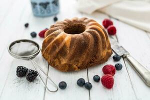 Kuchen. Marmor Kuchen Tasse von Kaffee Pulver Zucker Küche Jahrgang Utensil und frisch Obst Beeren foto