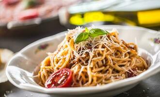 Spaghetti Bolognese mit Zutaten Basilikum Tomaten Parmesan Käse und Olive Öl foto