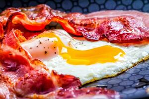 schön und äußerst lecker Schinken und Eier mit flüssig Eigelb und geröstet Speck foto