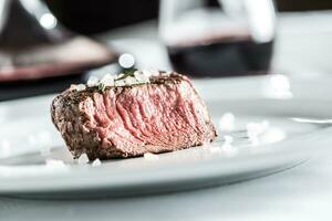 Rindfleisch Filet Steak auf Weiß Teller und rot Wein im Kneipe oder Restaurant foto