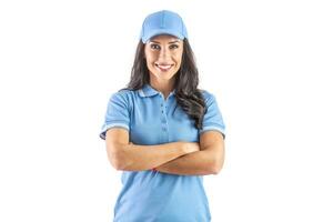 dunkelhaarig weit lächelnd Frau Stehen im Blau Deckel und T-Shirt mit Hände gekreuzt Über Brust. isoliert Hintergrund foto