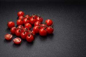köstlich frisch Kirsche Tomaten auf das Geäst wie ein Zutat zum Kochen ein Vegetarier Gericht foto