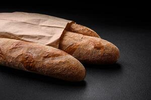 Französisch Stangenbrot Brot auf ein dunkel texturiert Beton Hintergrund foto