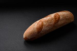 Französisch Stangenbrot Brot auf ein dunkel texturiert Beton Hintergrund foto