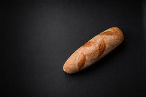 Französisch Stangenbrot Brot auf ein dunkel texturiert Beton Hintergrund foto