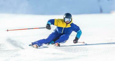 ein jung aggressiv Skifahrer auf ein alpin Steigung demonstriert ein extrem Carving Skifahren Stil. foto