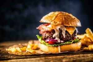 Nahansicht Zuhause gemacht Rindfleisch Burger mit Fritten auf hölzern Tabelle foto