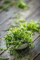 frisch Rucola Salat im Weiß Gericht auf hölzern Tabelle foto