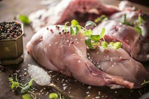 roh Hase Beine Salz- Pfeffer und Kräuter auf Metzger Tafel foto