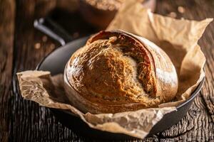 knusprig Hefe Brot Laib gemacht Lügen auf das Backen Papier im das rustikal Legierung schwenken foto