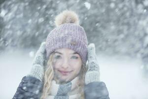 Porträt von jung schön Frau im Winter Kleider und stark schneit foto