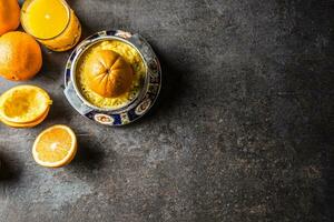 frisch Orangen Entsafter Saft und tropisch Früchte auf Beton Tafel foto