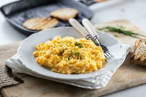 europäisch Frühstück mit durcheinander Eier mit Schnittlauch und Toast foto