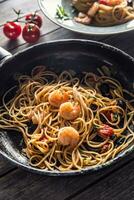 Pasta Spaghetti auf Teller und schwenken mit Garnele Tomate Soße Tomaten und Kräuter. Italienisch oder Mittelmeer Küche foto