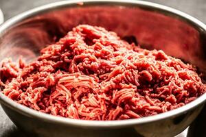 Metall Schüssel voll von frisch bereit Rindfleisch Fleisch zum Steak Tartar foto