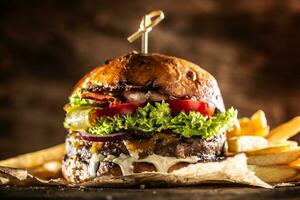 klassisch Rindfleisch Burger mit Käse Cheddar Speck wegtisch und Französisch Fritten foto