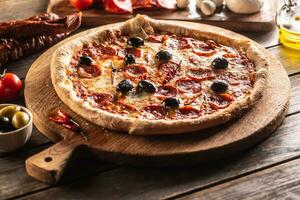 Pizza diavola traditionell Italienisch Mahlzeit mit würzig Salami Peperoni Chili und Oliven foto
