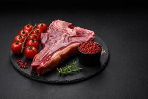 roh frisch saftig Rindfleisch T-Bone Steak mit Salz, Gewürze und Kräuter foto