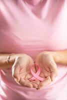 Rosa Band, ein International Symbol von Brust Krebs Bewusstsein, ist gehaltenen durch ein Frau im Rosa Hemd foto