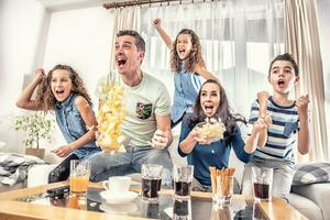 schwärmen Fans Jubel Sport, wie Familie von fünf Uhr Fußball, oder Eishockey Spiel auf das Fernseher beim heim, schreiend von Freude foto