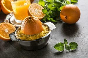 frisch Orangen Entsafter Saft tropisch Früchte und Kräuter auf Beton Tafel foto