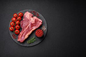 roh frisch saftig Rindfleisch T-Bone Steak mit Salz, Gewürze und Kräuter foto