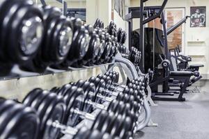 schwarz Hantel Satz. schließen oben viele gummiert Hanteln auf Gestell im Sport Fitness Center , Gewicht Ausbildung Ausrüstung Konzept foto