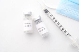 Nahaufnahme des Coronavirus-Impfstoffs und der Spritze auf weißem Hintergrund foto