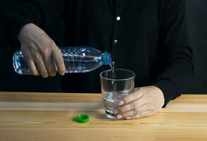 Frau Gießen Wasser in Glas trinken Wasser jeder Tag foto