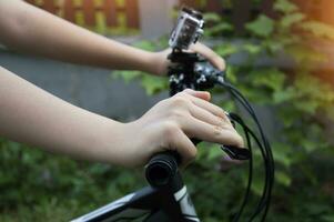 Frau Hand halten das Lenker von ein Berg Fahrrad foto