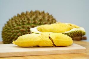 gelbfleischig Durian Fruchtfleisch, Sanft und Firma, mit ein appetitlich Aroma, schön vereinbart worden auf ein hölzern Schneiden Tafel auf ein Weiß Hintergrund. Sanft und selektiv Fokus. foto
