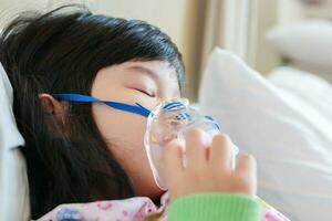 krank wenig asiatisch Mädchen Inhalation mit Vernebler zum Atemwege Behandlung foto