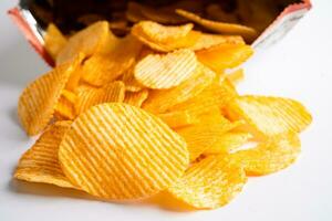 Kartoffelchips, leckeres Grillgewürz würzig für Crips, dünne Scheiben frittierter Snack Fast Food im offenen Beutel. foto