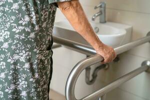 asiatisch Alten Frau geduldig verwenden Toilette Badezimmer Griff Sicherheit im Pflege- Krankenhaus, gesund stark medizinisch Konzept. foto