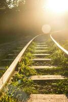 Eisenbahn Bahnhof Perspektive mit Sonnenuntergang Licht beim das Ende von das Straße foto